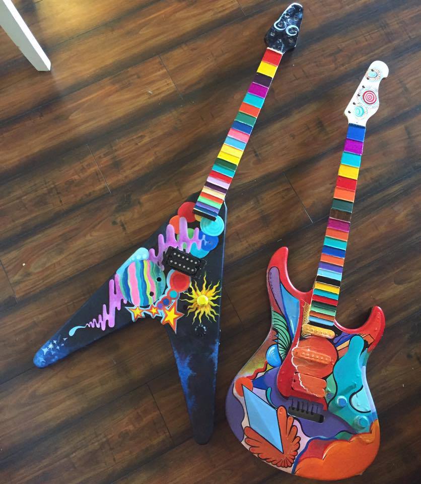 Two electric guitars covered in colorful hand-painted designs.